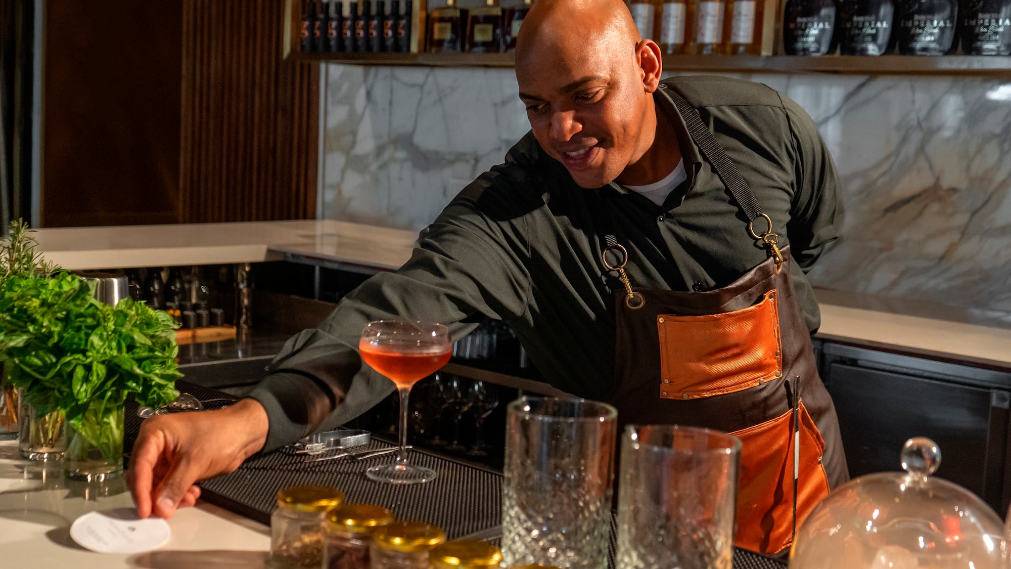 a man in an apron at a bar