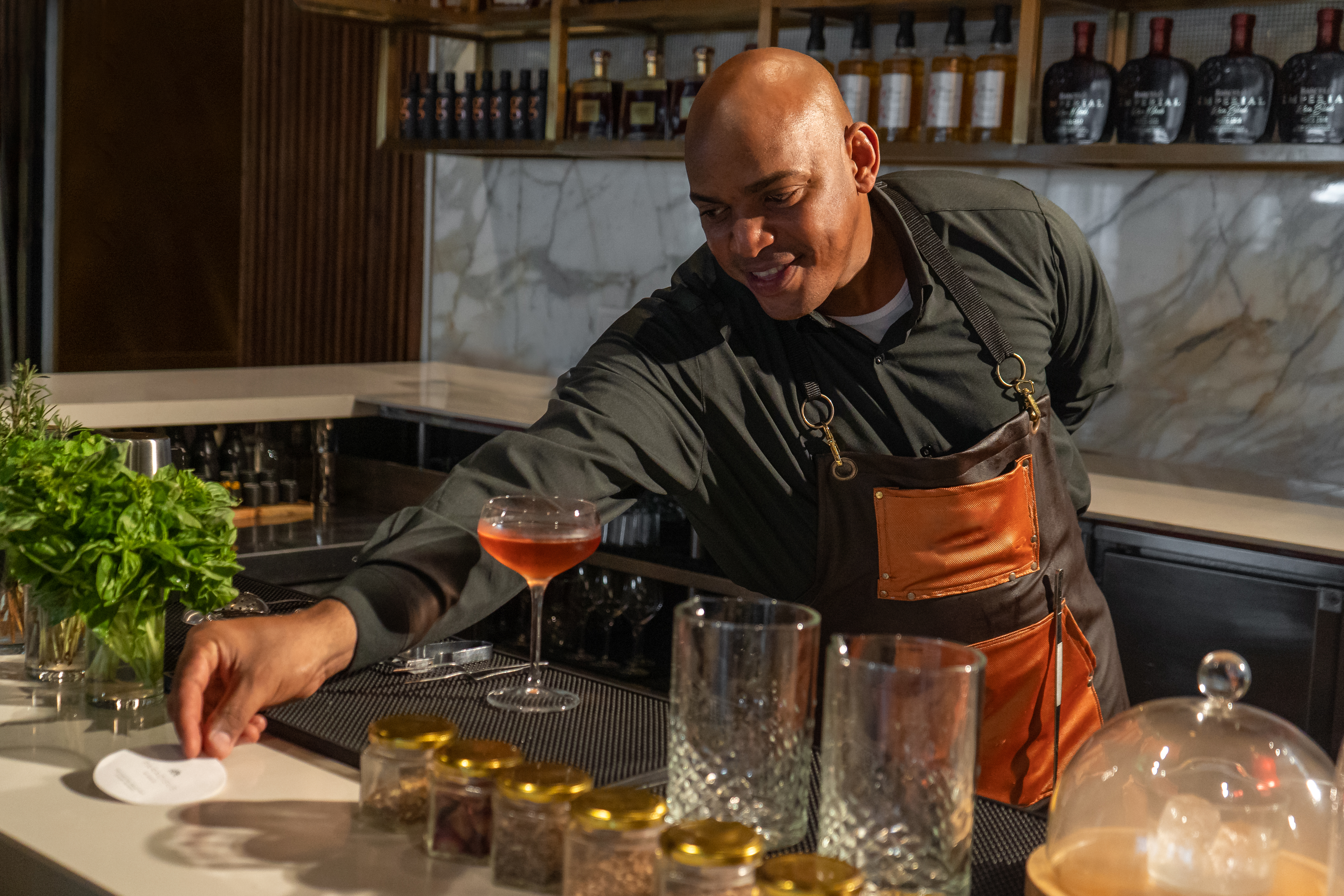 a man in an apron at a bar