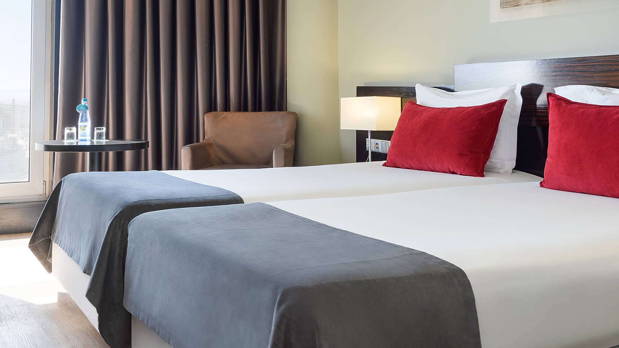 a room with two beds and a chair