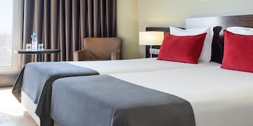 a room with two beds and a chair