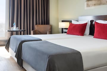 a room with two beds and a chair