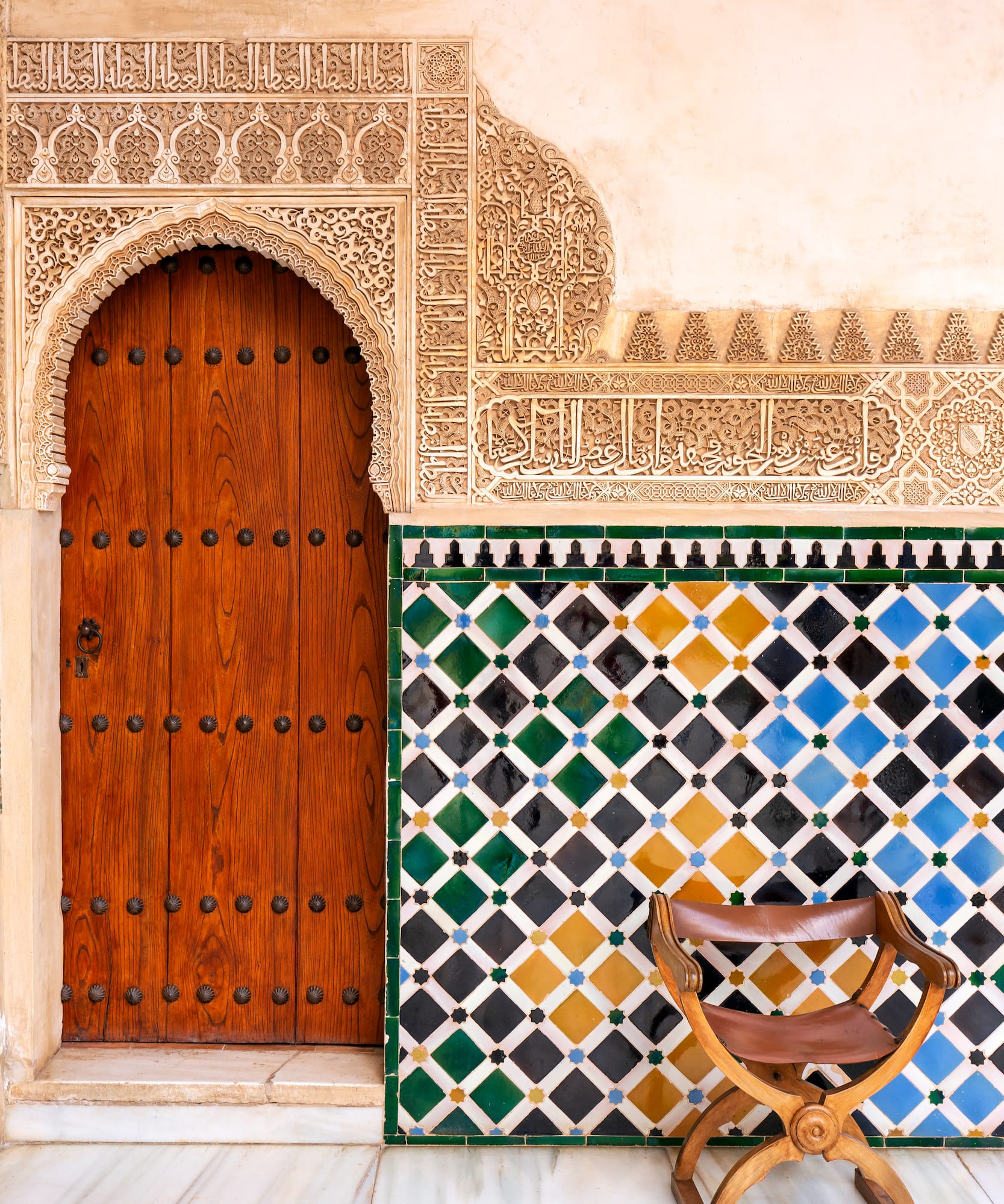a wooden door and colorful tile wall