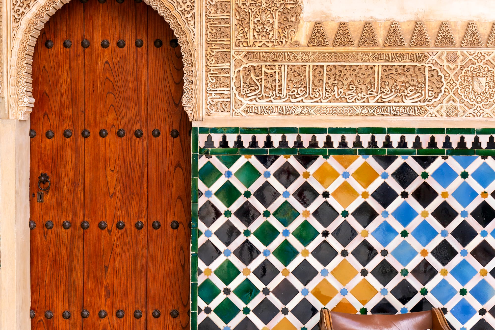 a wooden door and colorful tile wall