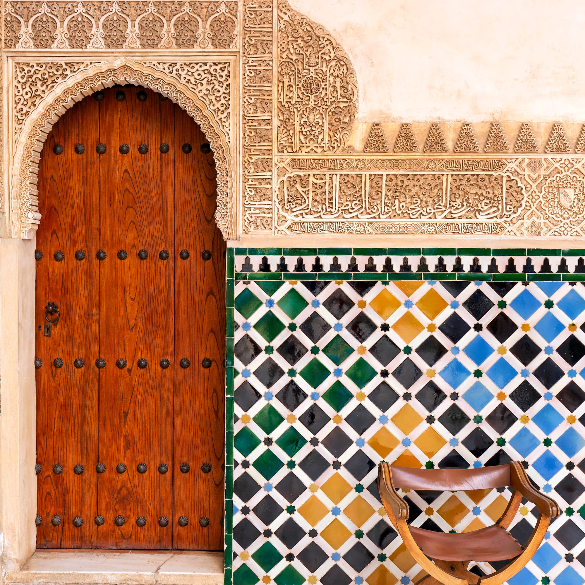a wooden door and colorful tile wall