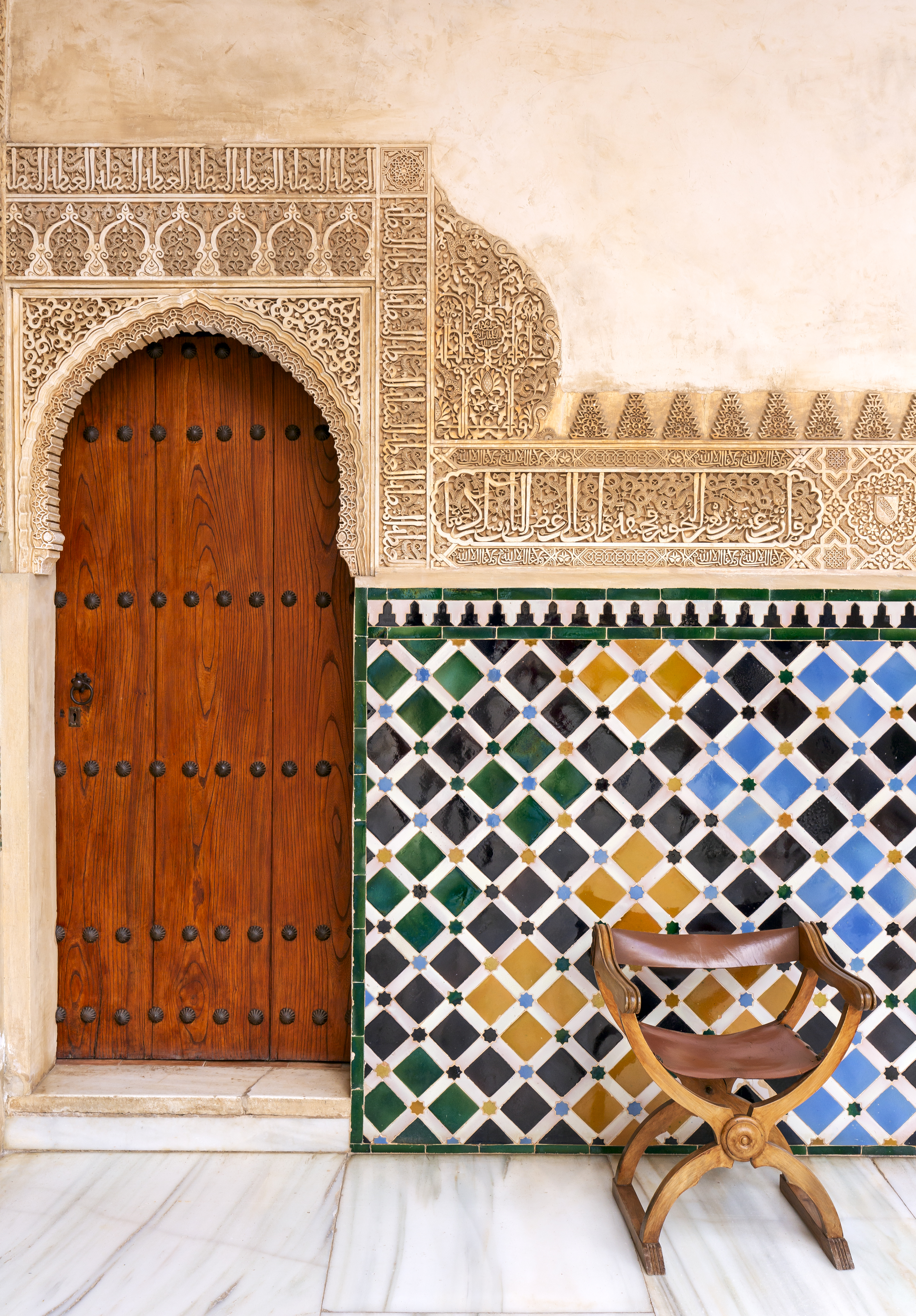 a wooden door and colorful tile wall
