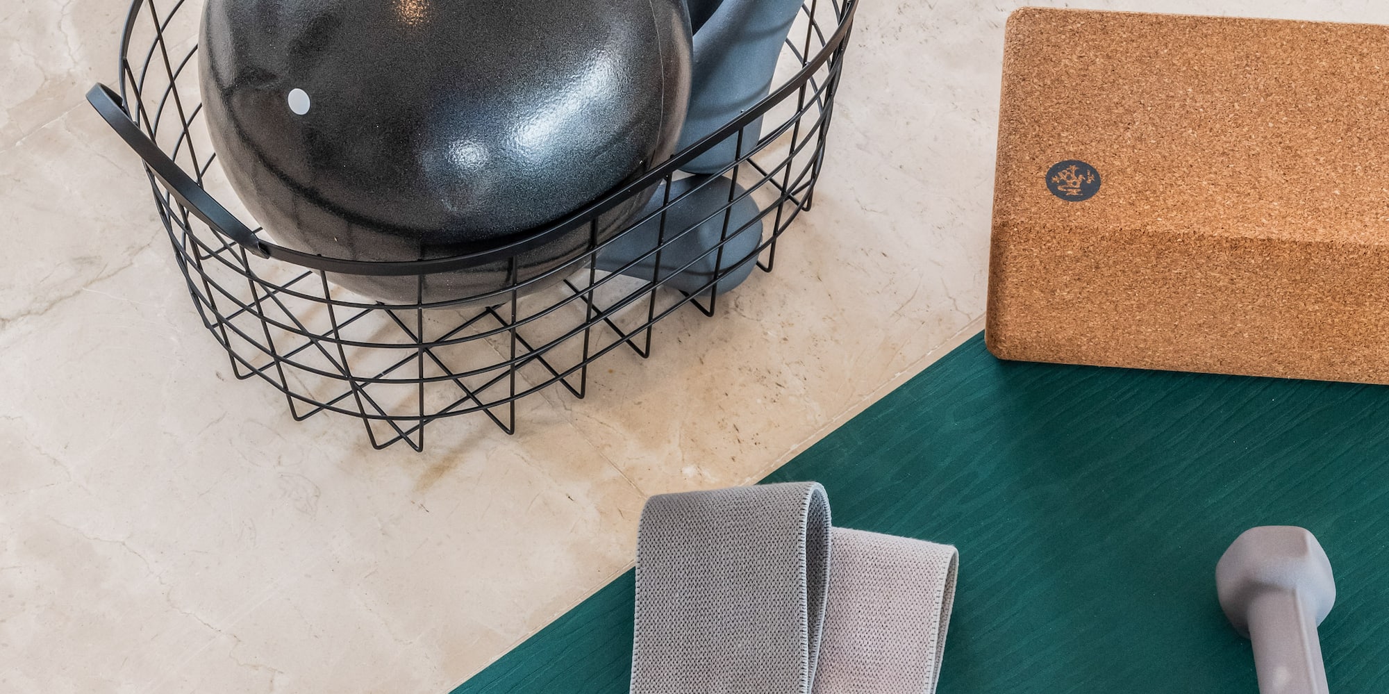 a black ball in a wire basket next to a pair of dumbbells