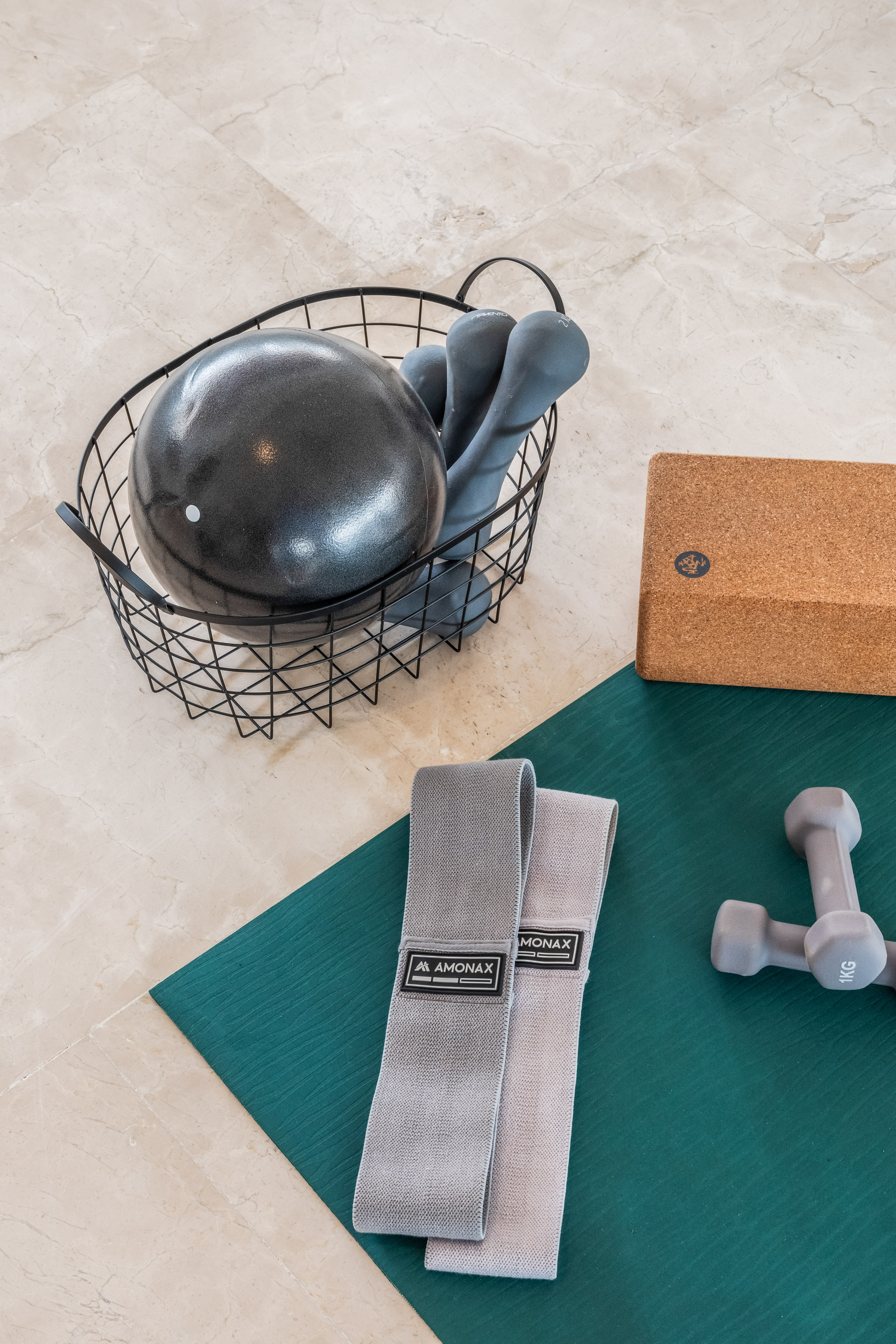 a black ball in a wire basket next to a pair of dumbbells