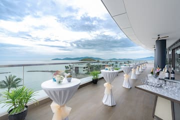 a table set up on a deck with a view of the ocean