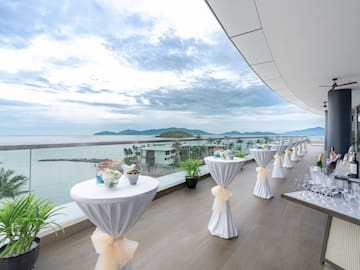 a table set up on a deck with a view of the ocean