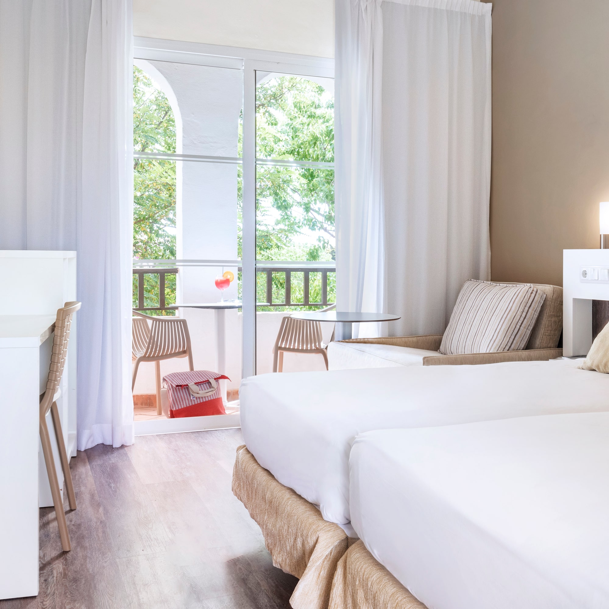 a room with two beds and a table and chairs