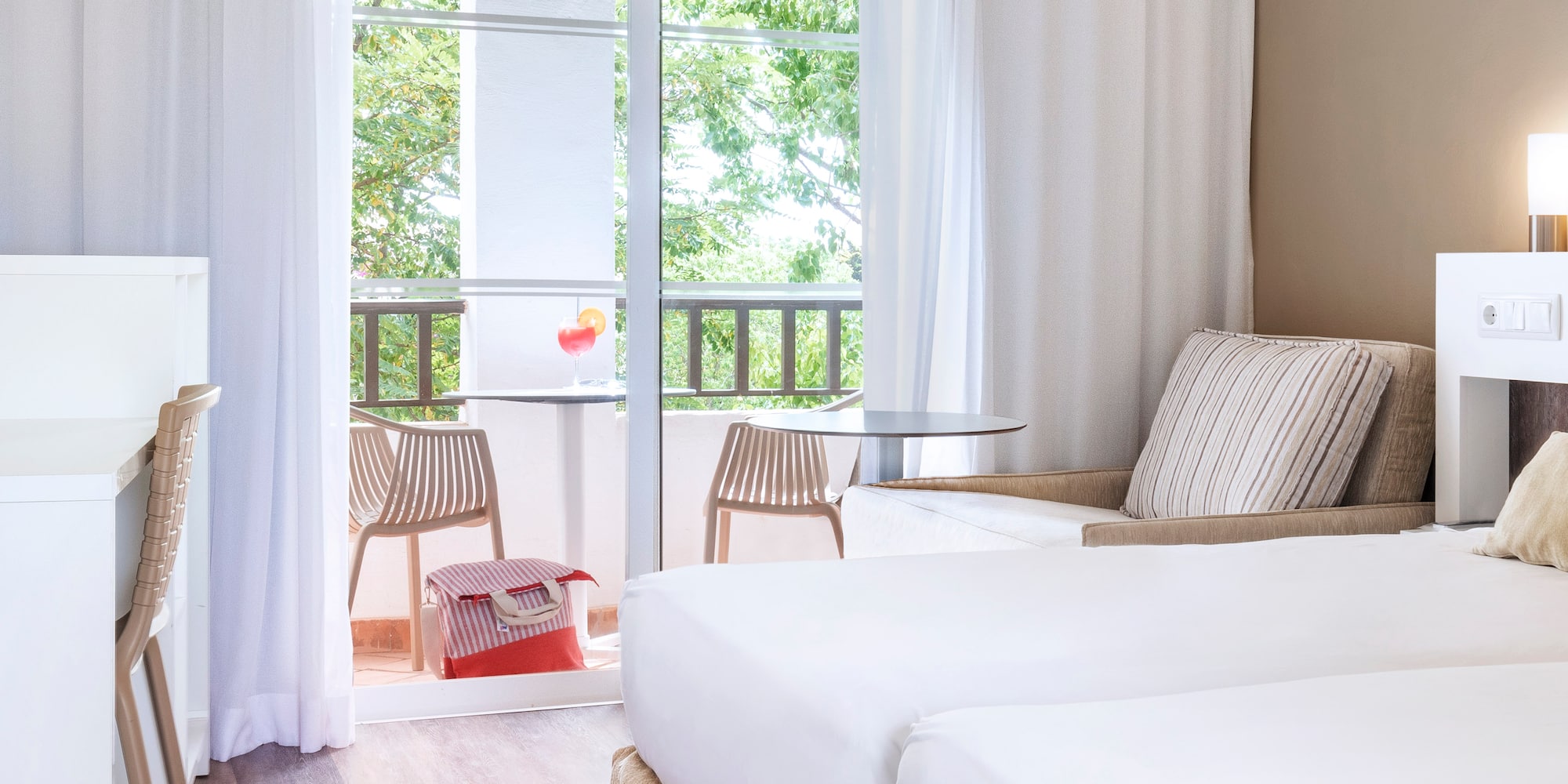 a room with two beds and a table and chairs