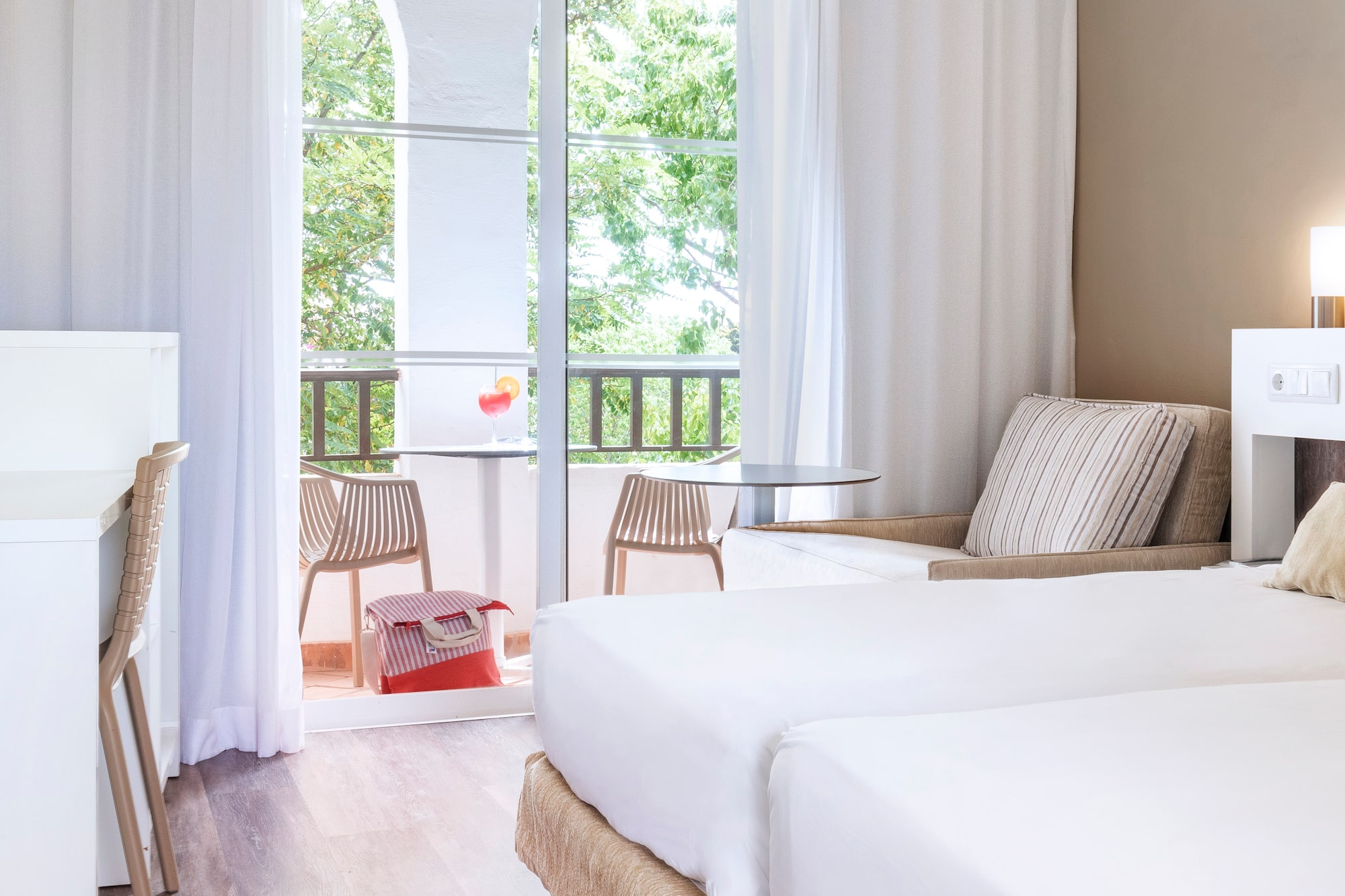 a room with two beds and a table and chairs