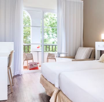 a room with two beds and a table and chairs