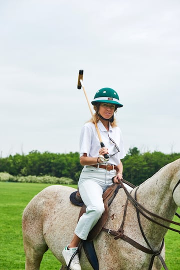 a woman on a horse with a polo stick