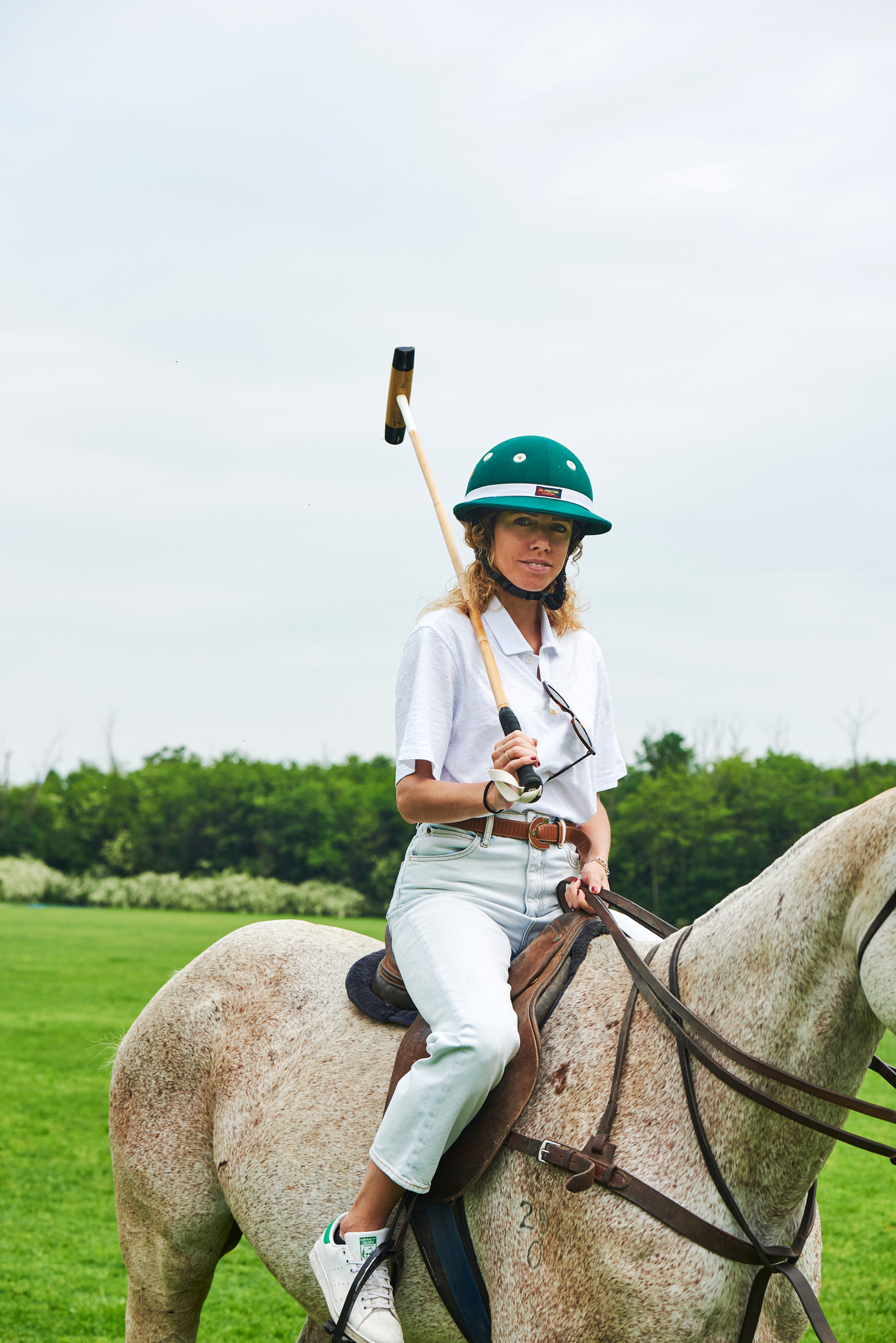 a woman on a horse with a polo stick