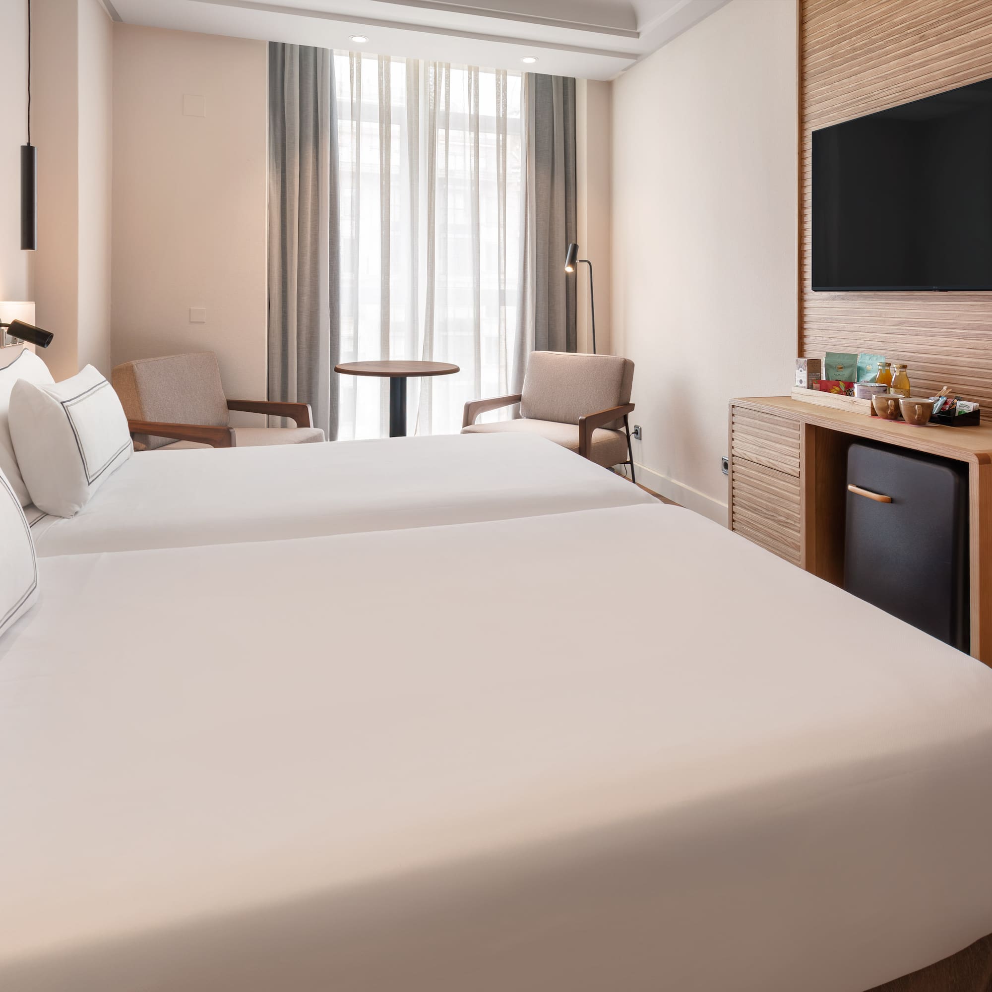 a room with two beds and a television