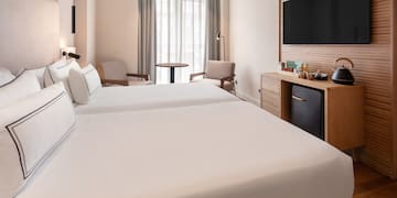 a room with two beds and a television