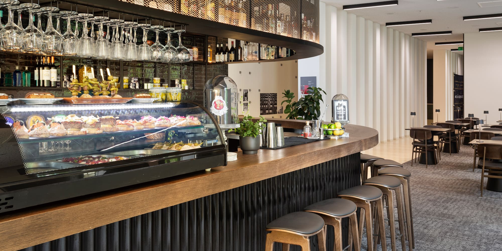 a bar with a counter and wine glasses