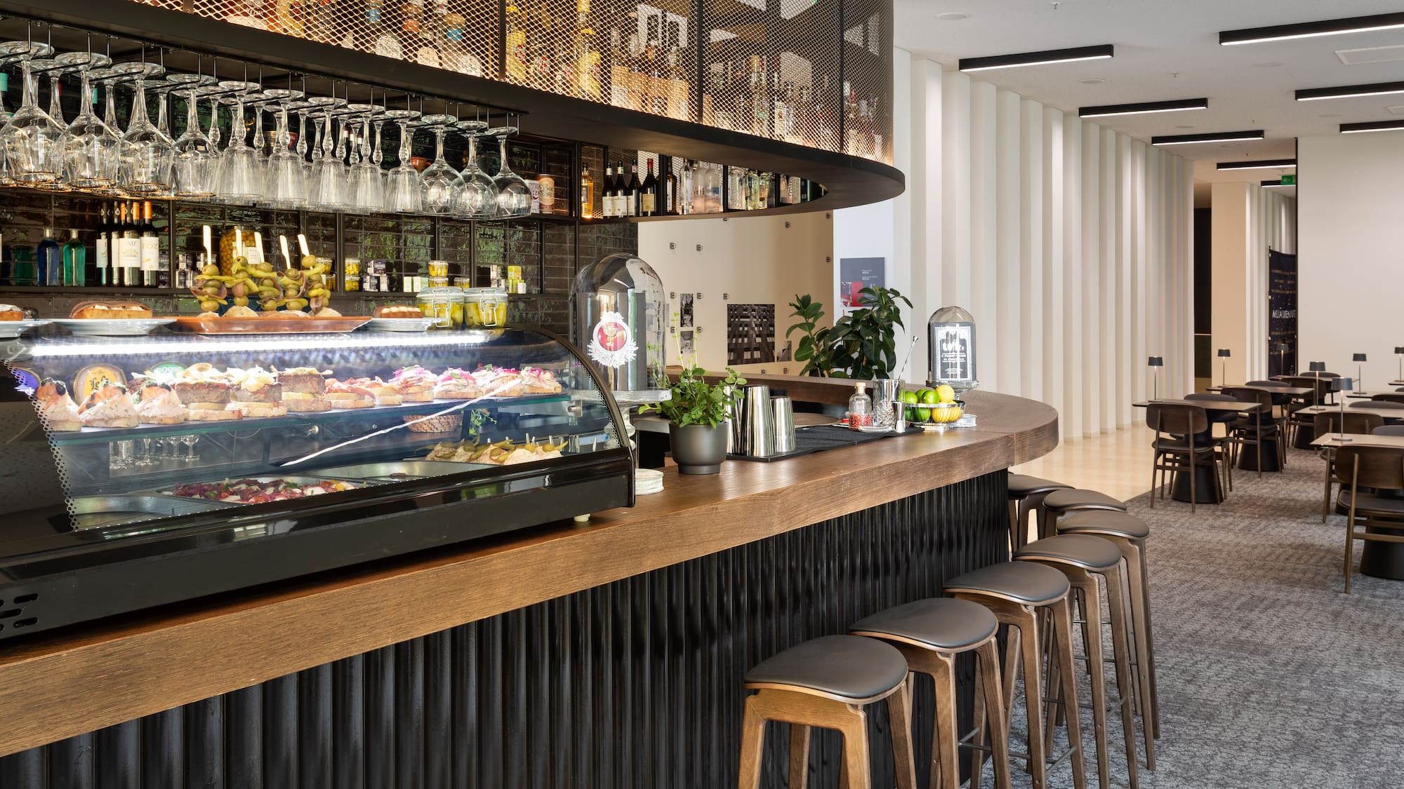 a bar with a counter and wine glasses