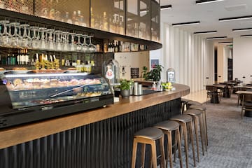 a bar with a counter and wine glasses
