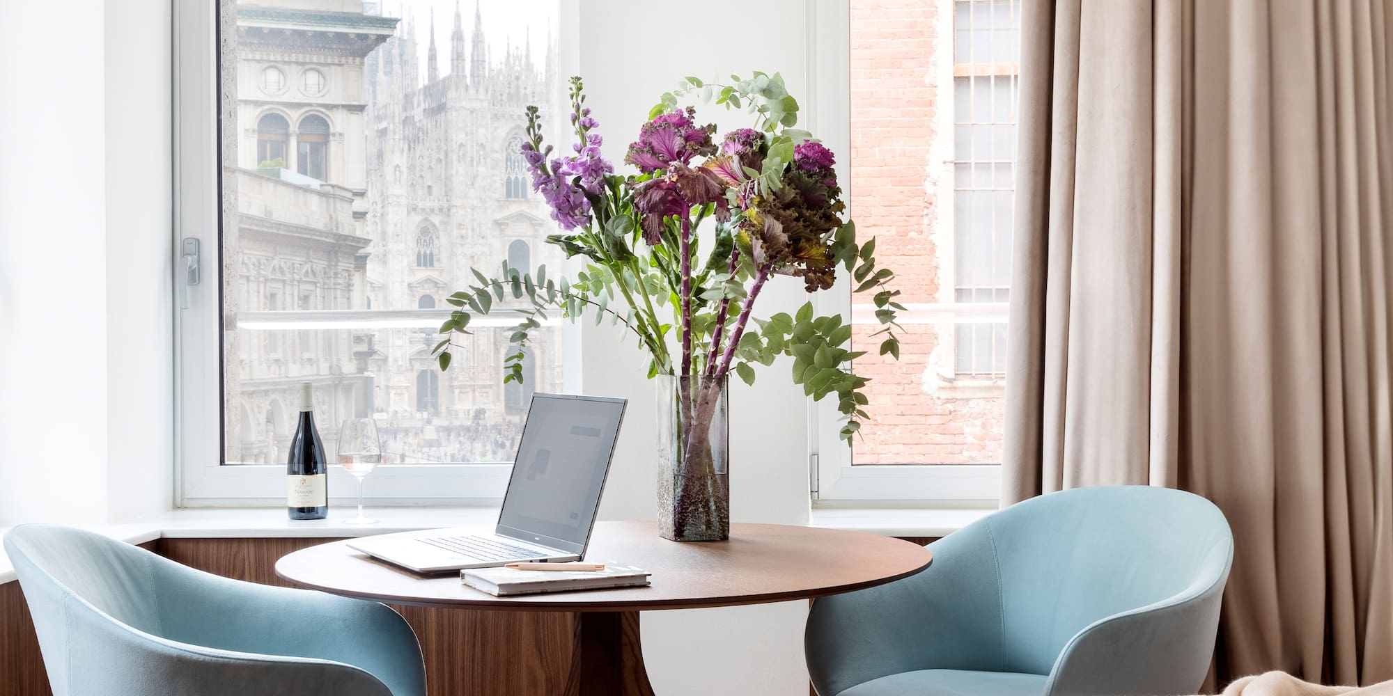 a vase of flowers on a table by a window