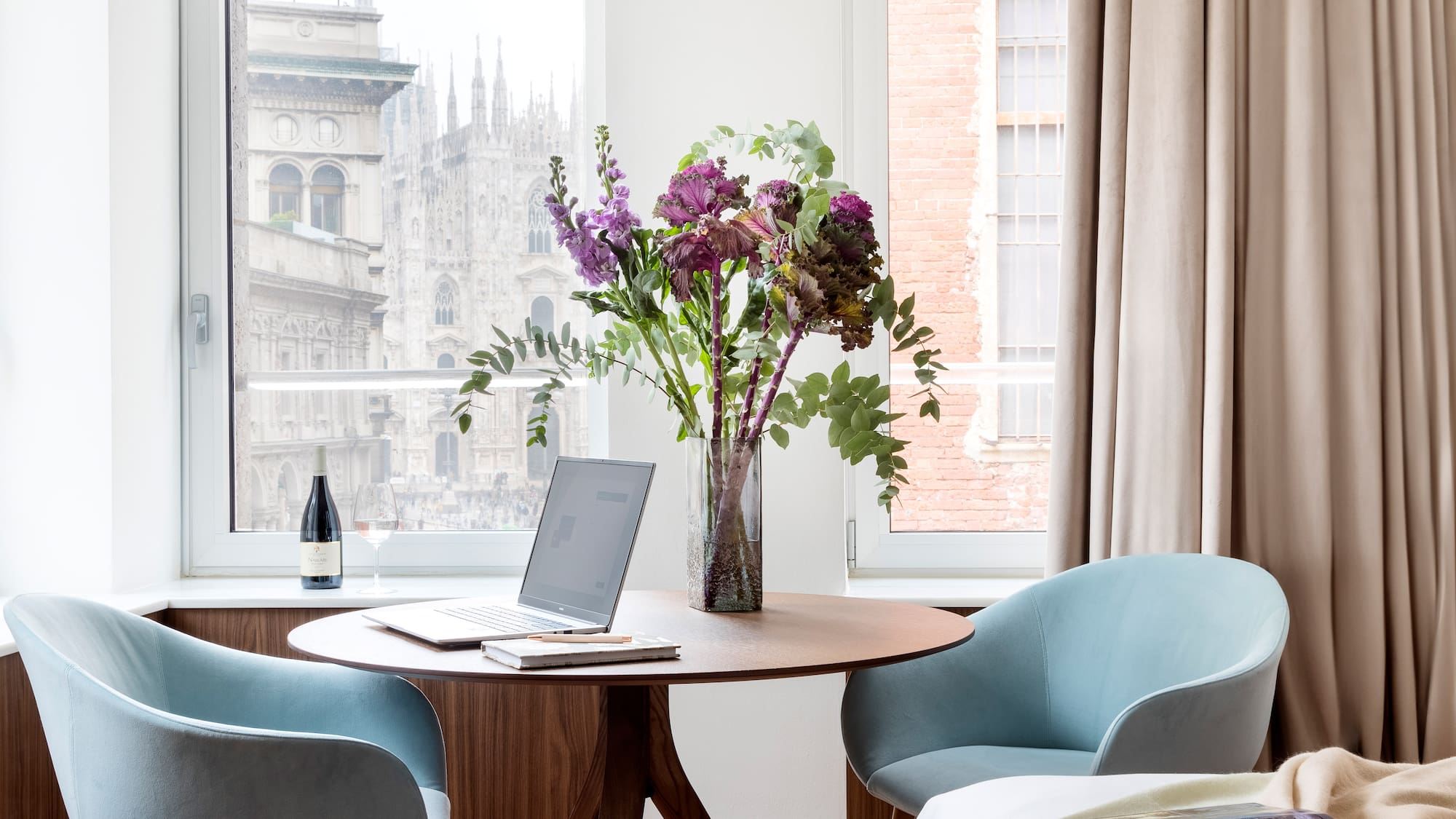 a vase of flowers on a table by a window