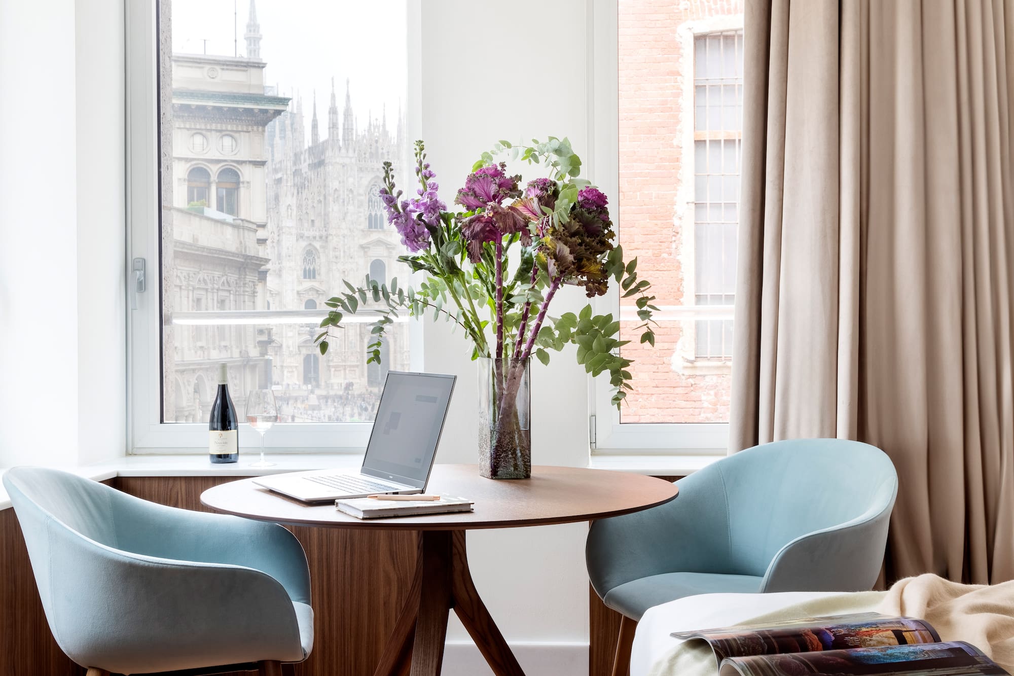 a vase of flowers on a table by a window