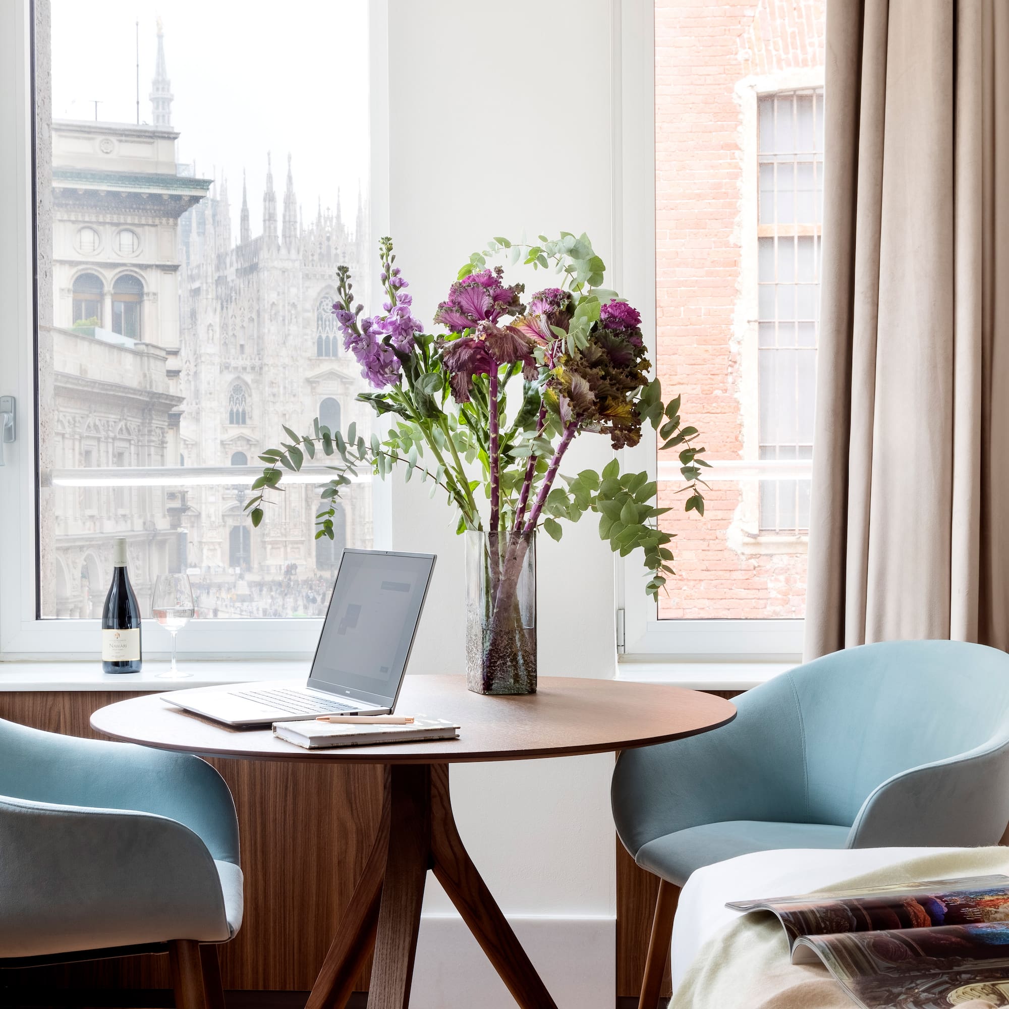 a vase of flowers on a table by a window