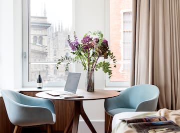 a vase of flowers on a table by a window