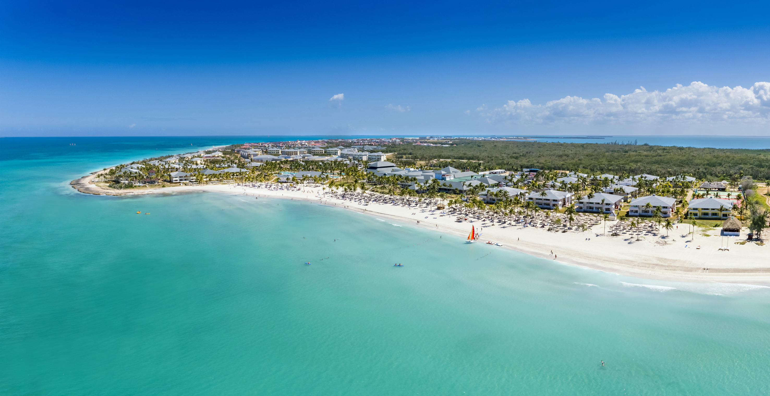 a beach with buildings and a body of water
