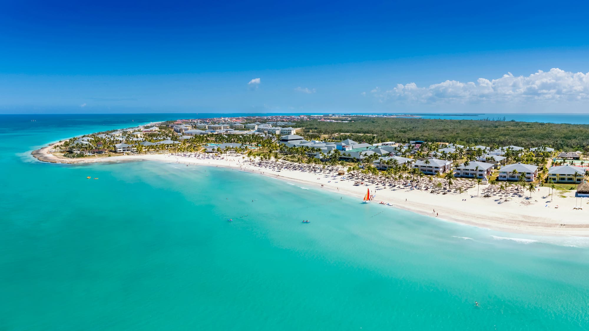 a beach with buildings and a body of water