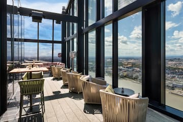 a room with chairs and tables and a view of a city