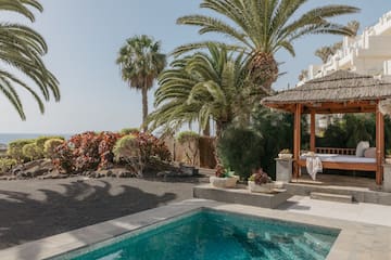 a pool with a gazebo and palm trees