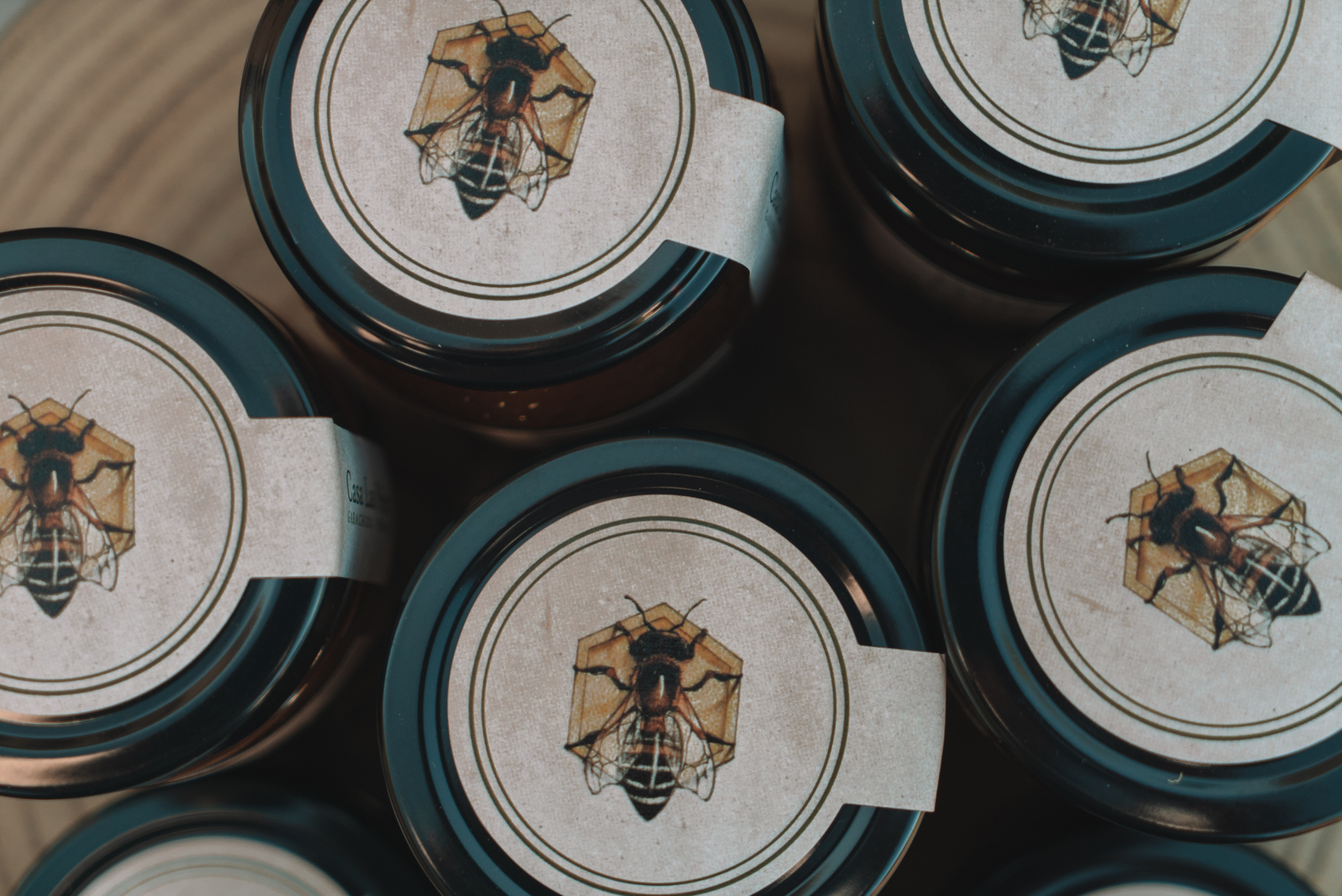 Tarros de miel con etiquetas de abeja y celda de panal.
