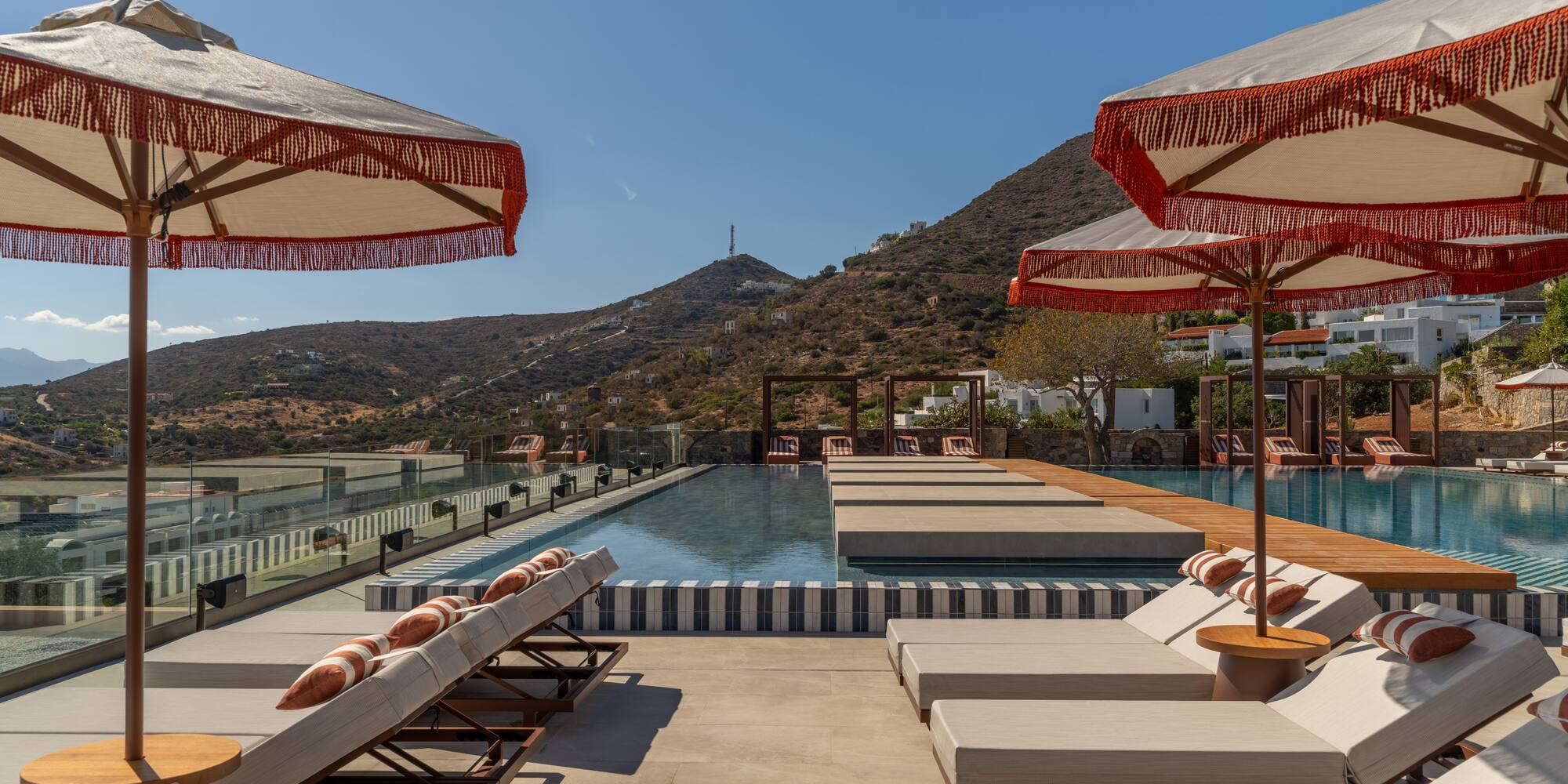a pool with umbrellas and lounge chairs