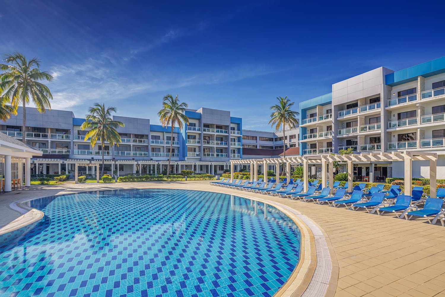 a pool with lounge chairs and palm trees