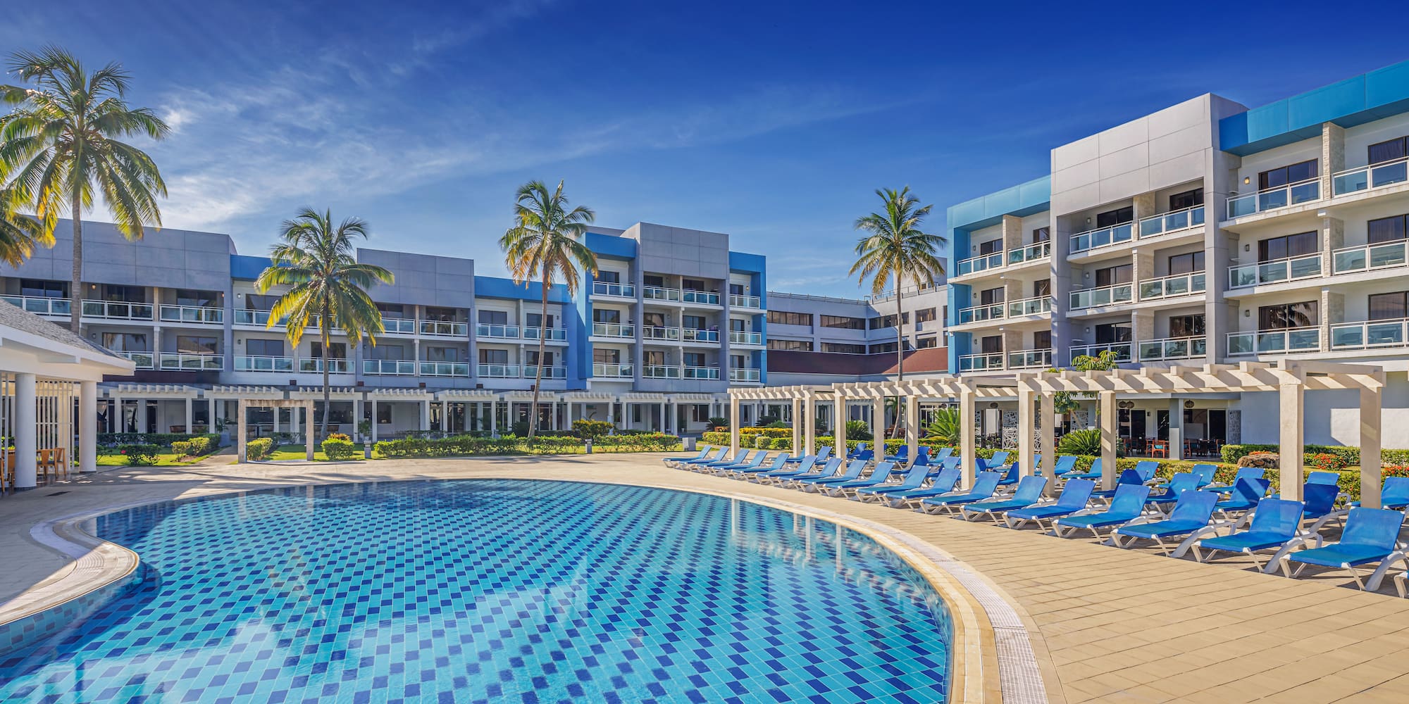 a pool with lounge chairs and palm trees