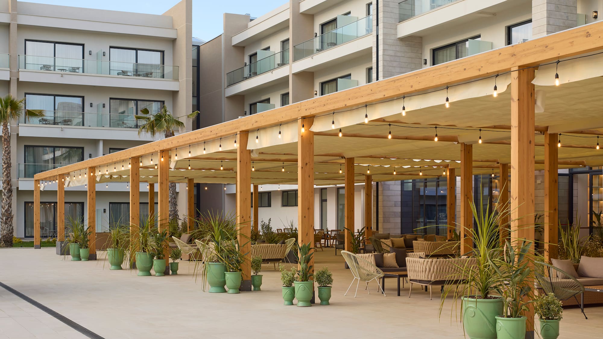 a patio with a covered area with chairs and a table and chairs