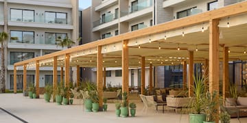 a patio with a covered area with chairs and a table and chairs