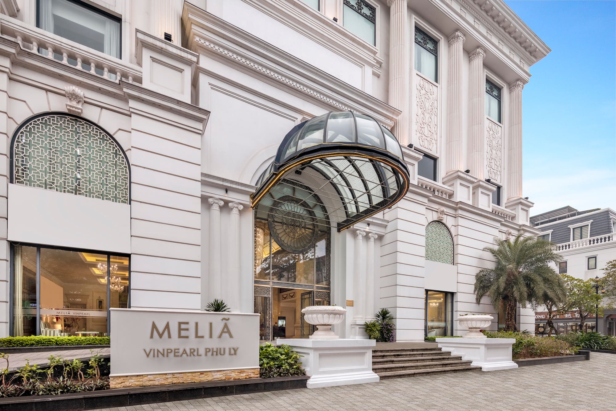 Melia Vinpearl Phu Ly hotel facade with grand entrance and glass canopy.