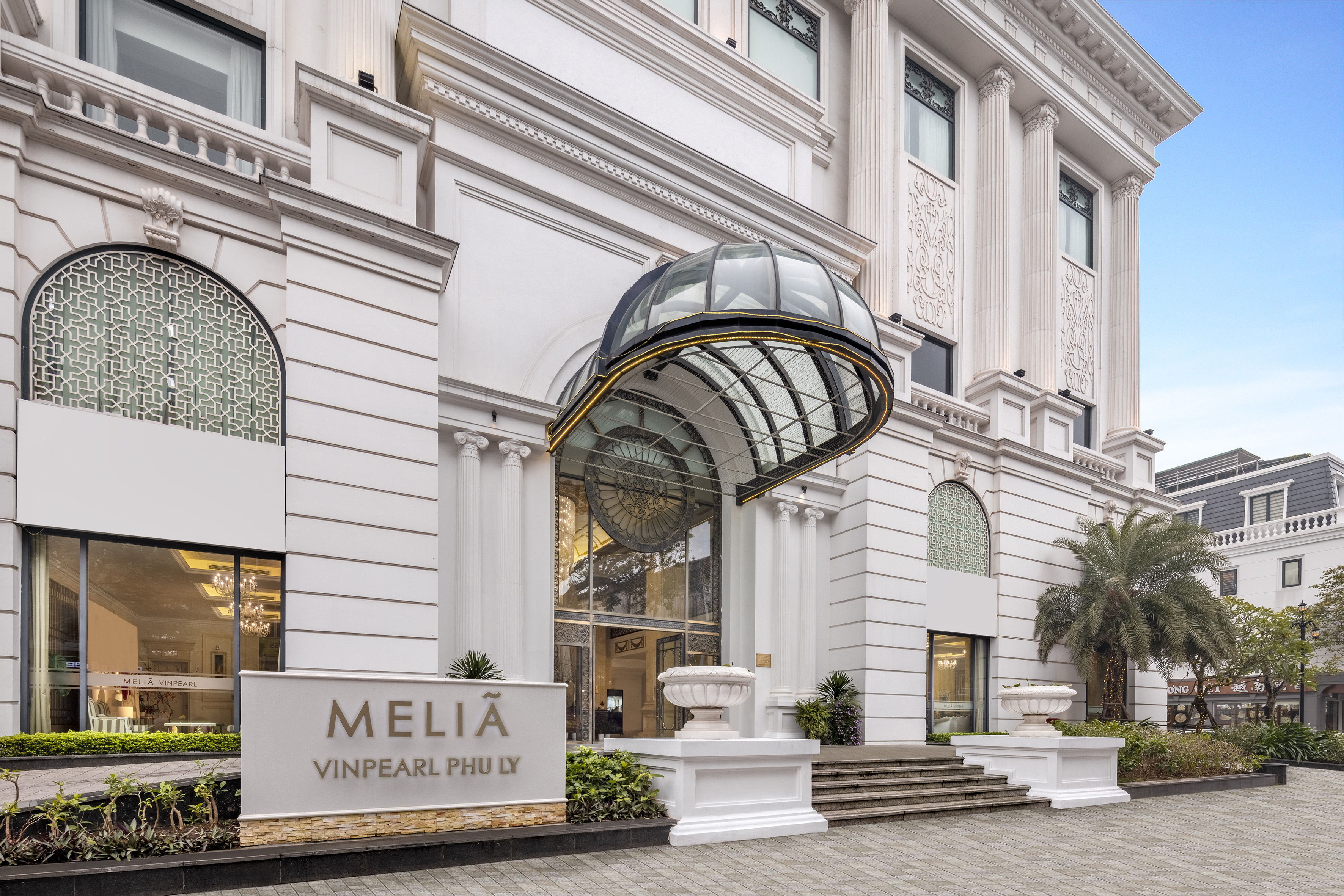 Melia Vinpearl Phu Ly hotel facade with grand entrance and glass canopy.