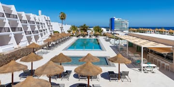 a pool with umbrellas and chairs in a resort