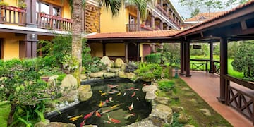a pond with fish in it surrounded by trees and Jim Thompson House