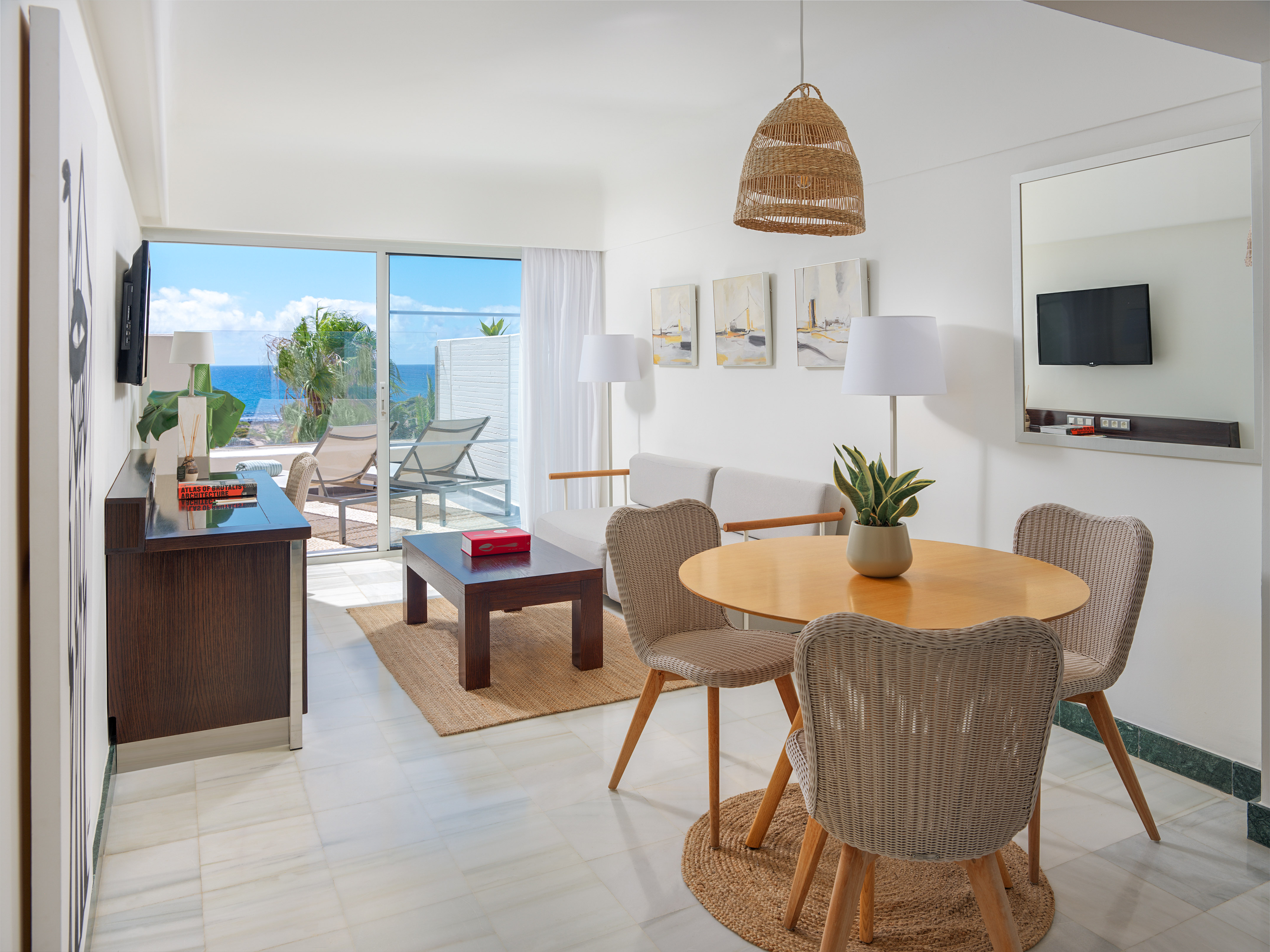 Hotel apartment with ocean view balcony, living room, and dining area.