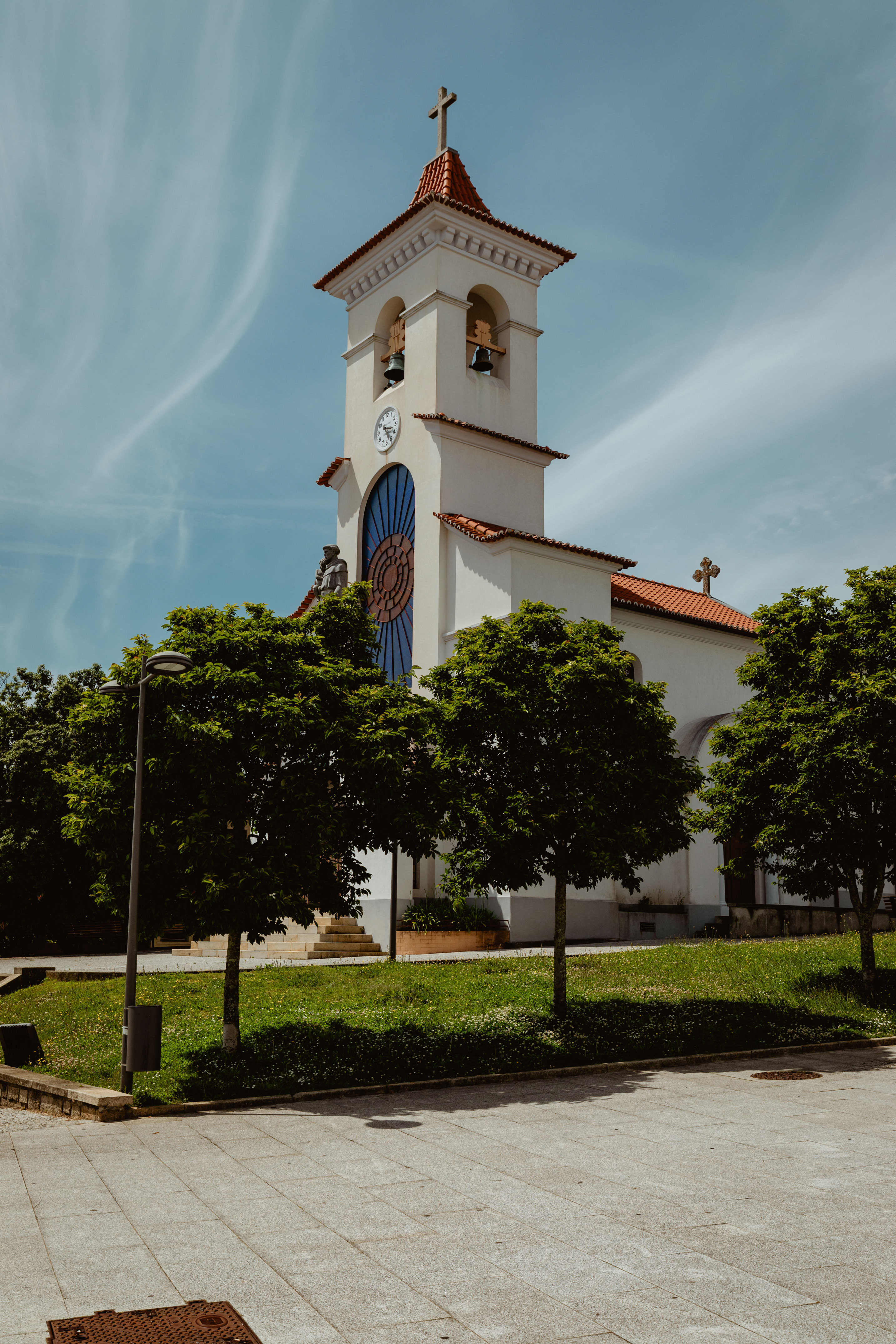 a white church with a clock tower and trees