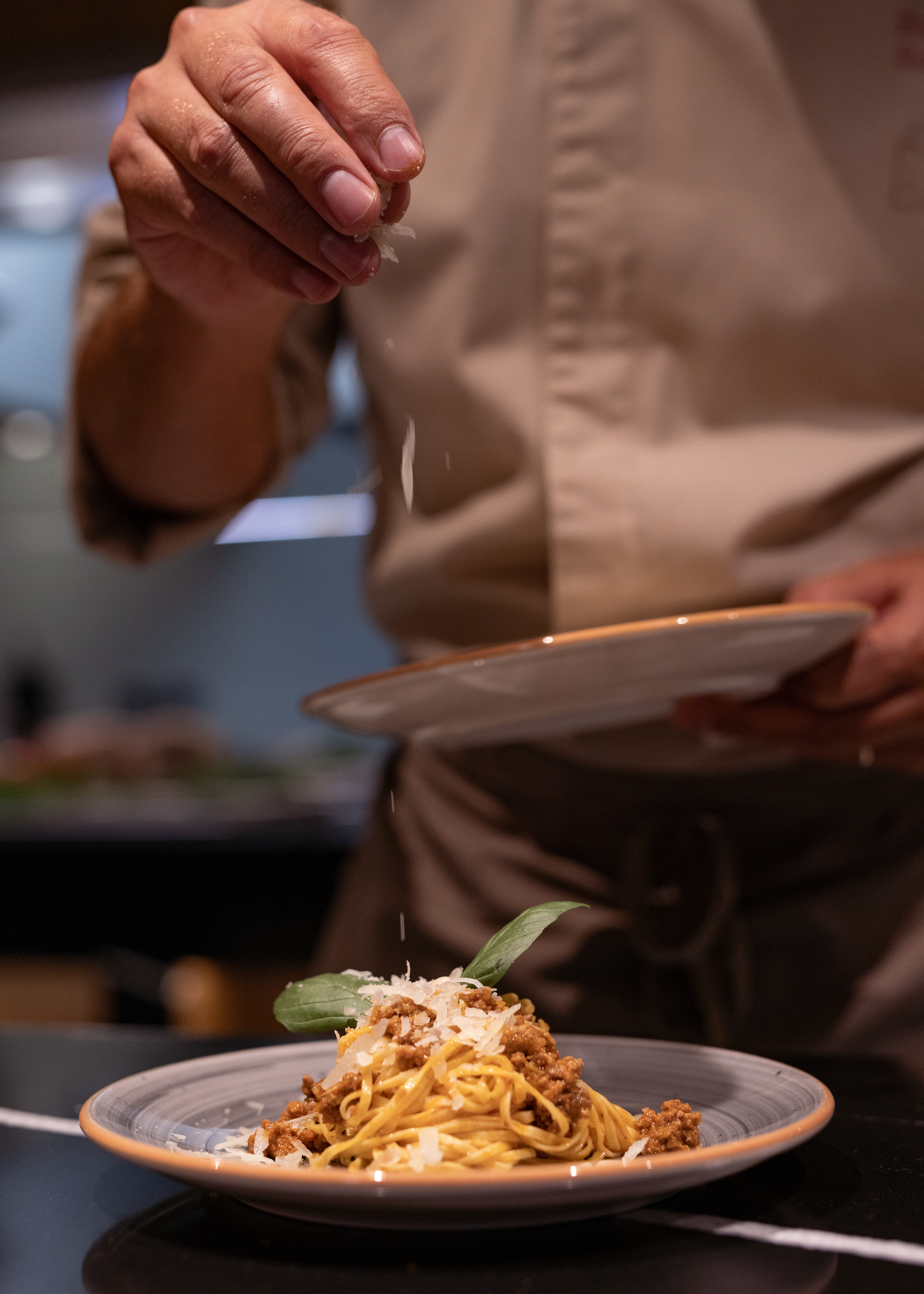 a person sprinkling salt on a plate of food