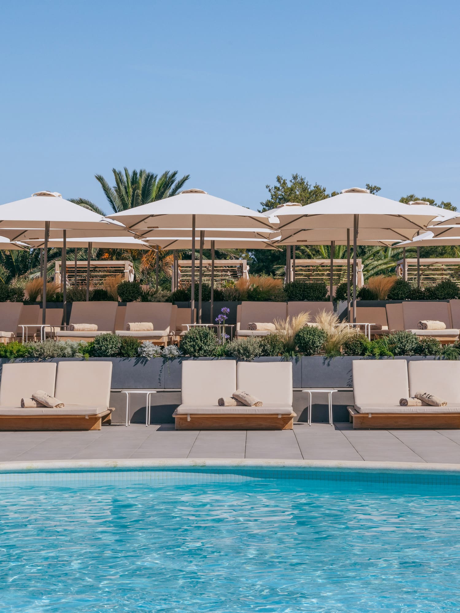 a pool with lounge chairs and umbrellas