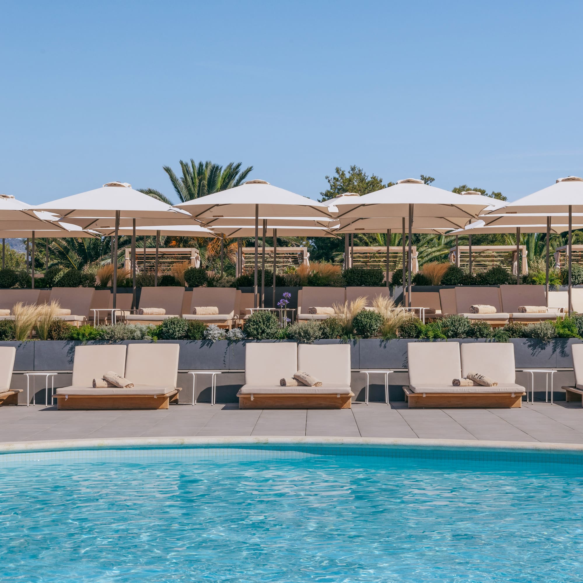 a pool with lounge chairs and umbrellas