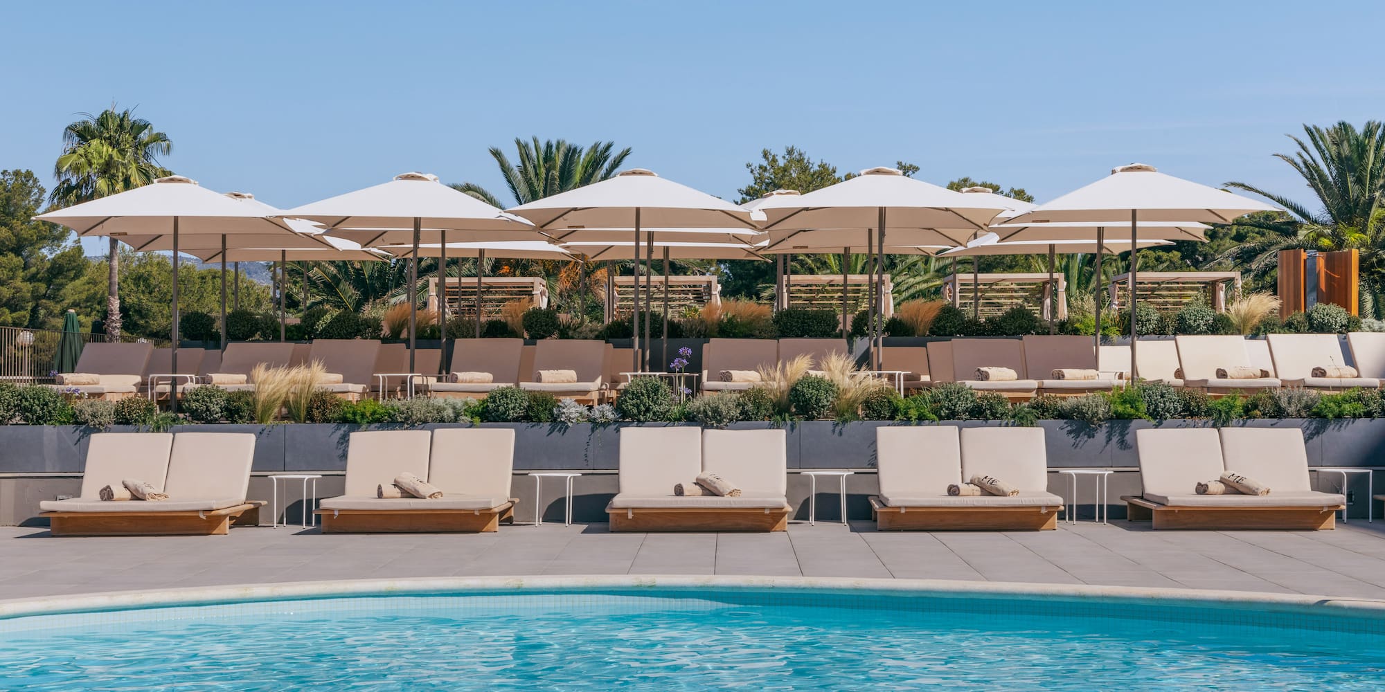 a pool with lounge chairs and umbrellas