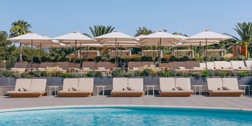 a pool with lounge chairs and umbrellas